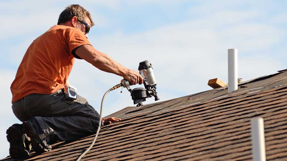 Roofing contractor installing asphalt shingle roof