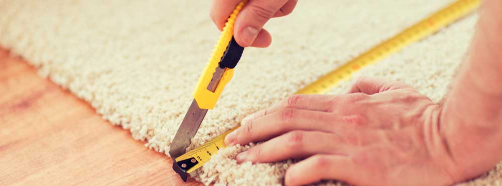 Flooring installer measuring carpeting