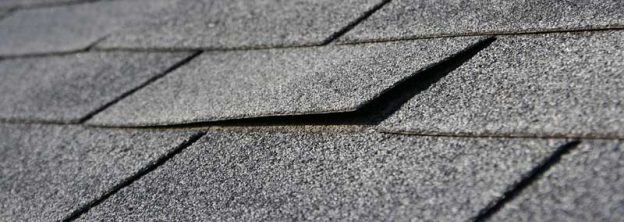 Lifting edge of a roof shingle indicating that the roof should be replaced