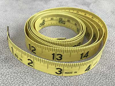 sewing tape measure coiled up showing measurement markings