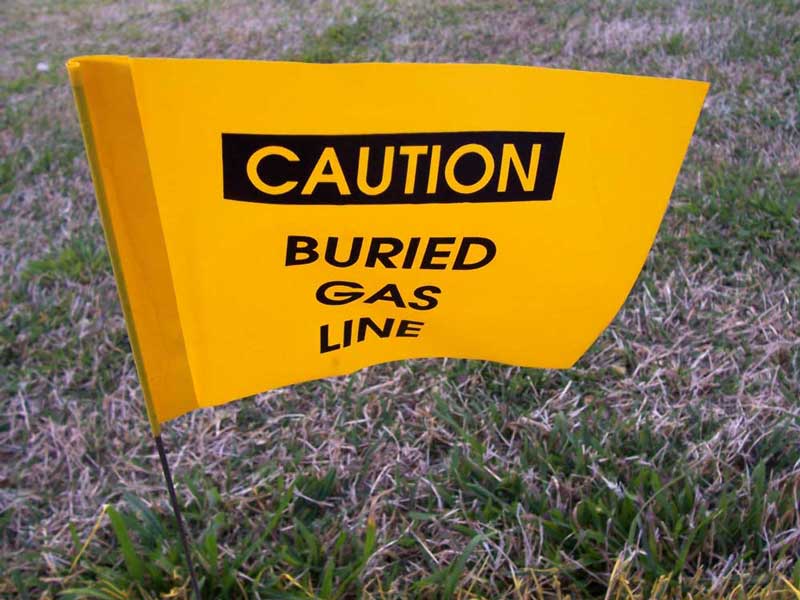 warning flag indicating a gas line is buried beneath the ground