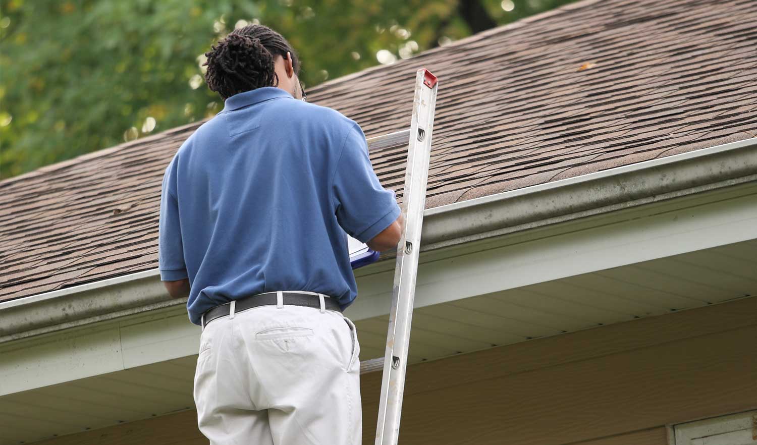 Inspector examining a roof for concerns or needed repairs